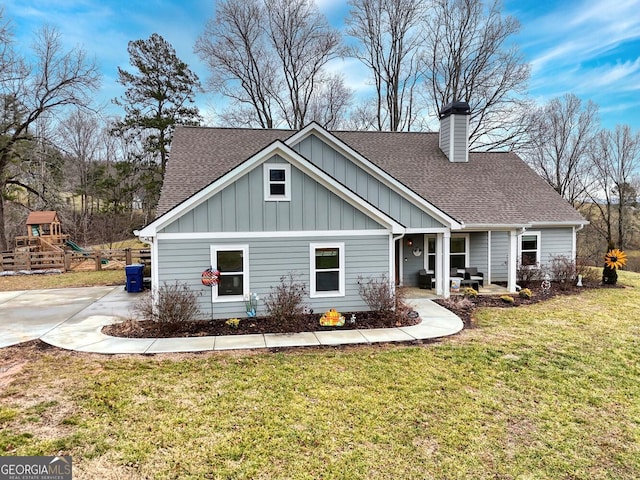 rear view of property featuring a yard and a playground