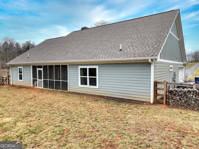 rear view of property with a yard and a sunroom