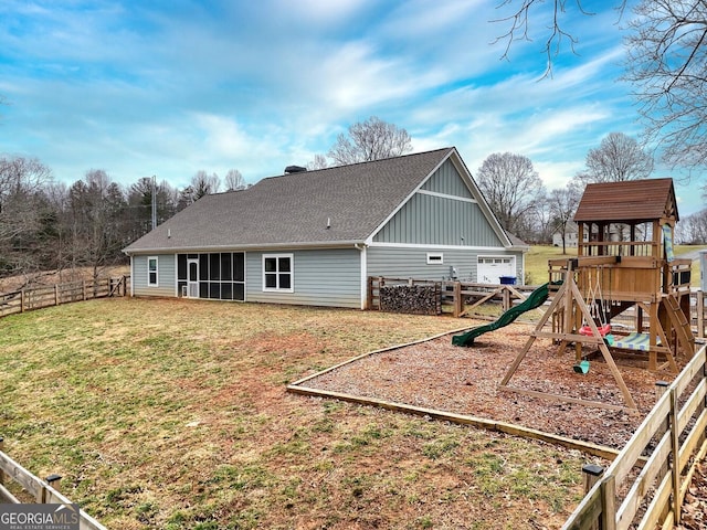 back of property featuring a playground and a lawn