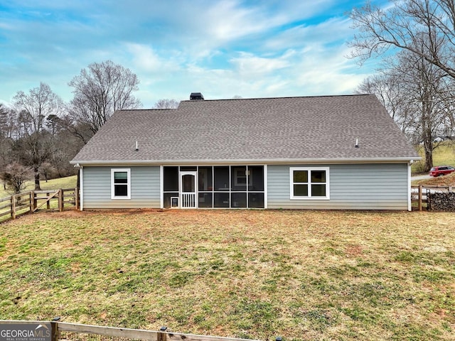 rear view of property featuring a sunroom and a lawn