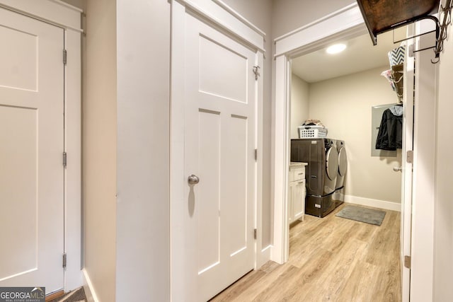 clothes washing area featuring washer and dryer and light hardwood / wood-style flooring