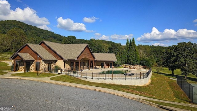 view of front of house featuring a fenced in pool and a patio