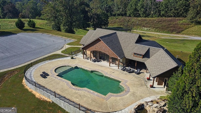 view of pool with a patio and a lawn