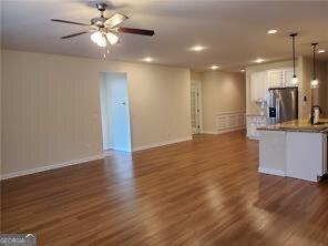 unfurnished living room with dark wood-type flooring and ceiling fan