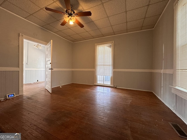 empty room featuring a paneled ceiling, dark hardwood / wood-style floors, and ceiling fan