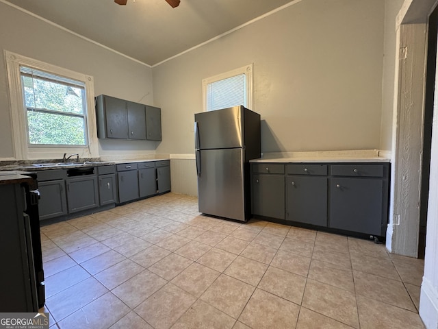 kitchen with crown molding, stainless steel fridge, ceiling fan, gray cabinetry, and light tile patterned flooring