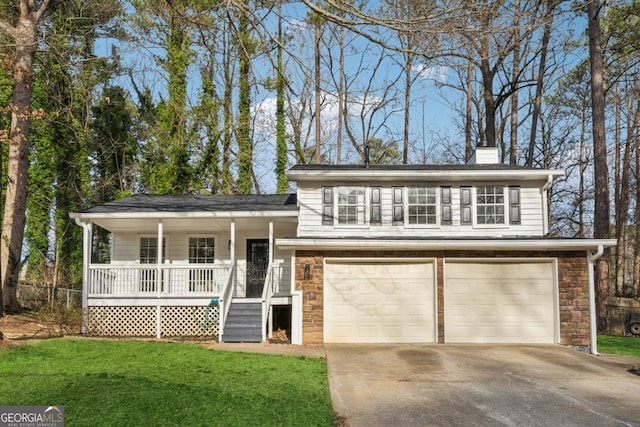 view of front of home with a garage, a front yard, and covered porch