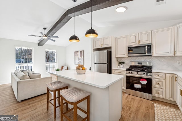 kitchen featuring light hardwood / wood-style flooring, stainless steel appliances, a kitchen breakfast bar, lofted ceiling with beams, and decorative light fixtures