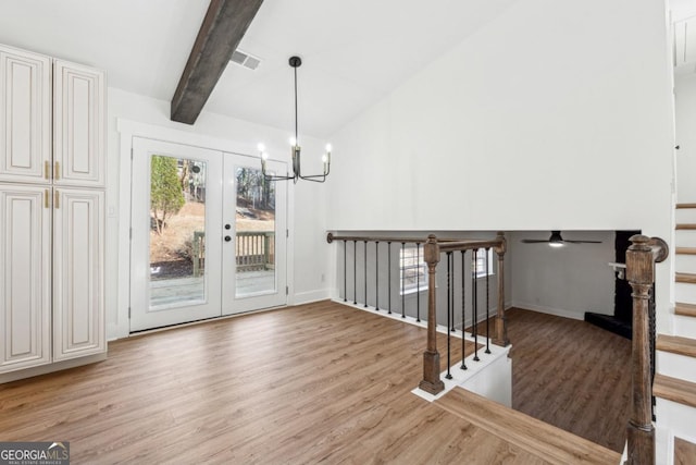 interior space with hardwood / wood-style floors, high vaulted ceiling, beamed ceiling, a notable chandelier, and french doors