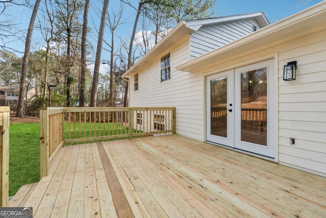 wooden deck with a yard and french doors