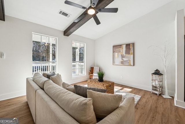 living room with ceiling fan, wood-type flooring, and lofted ceiling with beams