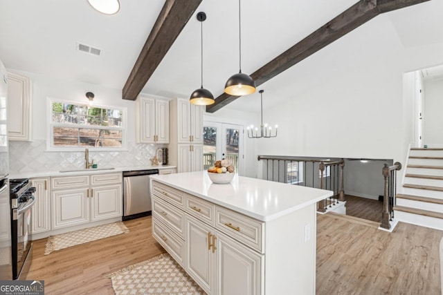 kitchen with decorative light fixtures, sink, vaulted ceiling with beams, a center island, and stainless steel appliances