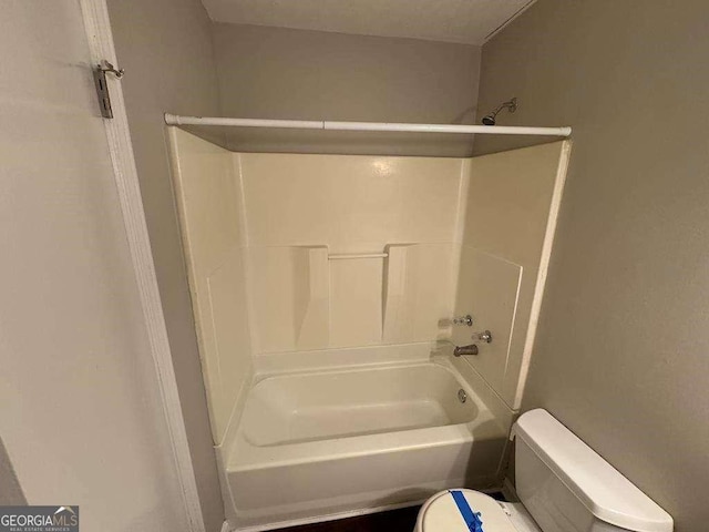 bathroom with bathing tub / shower combination and toilet