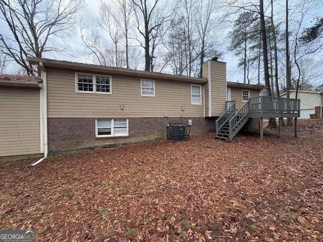 rear view of property featuring a wooden deck and central air condition unit