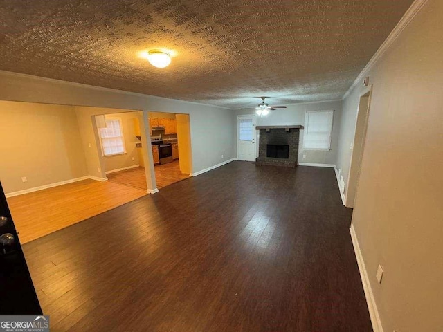 unfurnished living room featuring hardwood / wood-style flooring, a wealth of natural light, a textured ceiling, and ceiling fan