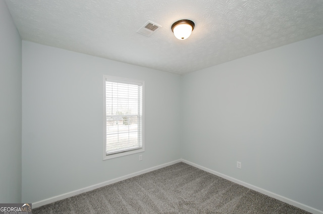 carpeted spare room with a textured ceiling