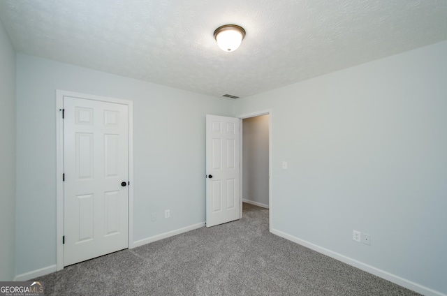 unfurnished bedroom with carpet floors and a textured ceiling