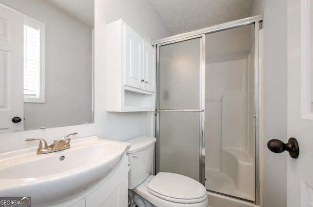 bathroom featuring vanity, a shower with shower door, and toilet