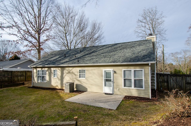 rear view of house featuring a yard, a patio, and central air condition unit