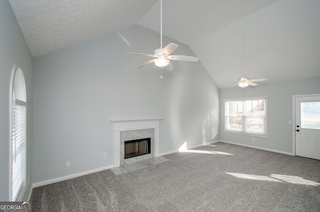 unfurnished living room with a premium fireplace, high vaulted ceiling, light carpet, and ceiling fan