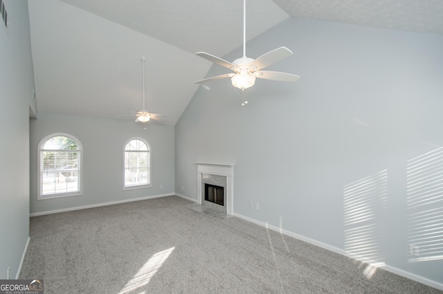 unfurnished living room with ceiling fan, a premium fireplace, high vaulted ceiling, and light carpet