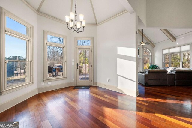 interior space featuring hardwood / wood-style flooring, ceiling fan with notable chandelier, high vaulted ceiling, and beamed ceiling