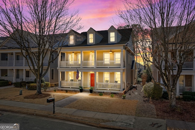 view of front facade with ceiling fan, a porch, and a balcony