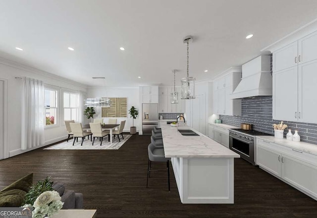 kitchen with light stone counters, high end stainless steel range, custom range hood, a center island with sink, and decorative light fixtures