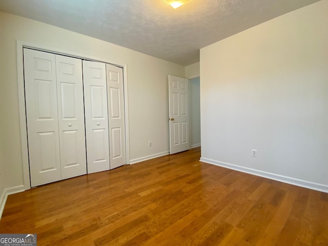 4299 High Country Dr, Douglasville, GA 30135 - unfurnished bedroom with hardwood / wood-style floors, a closet, and a textured ceiling