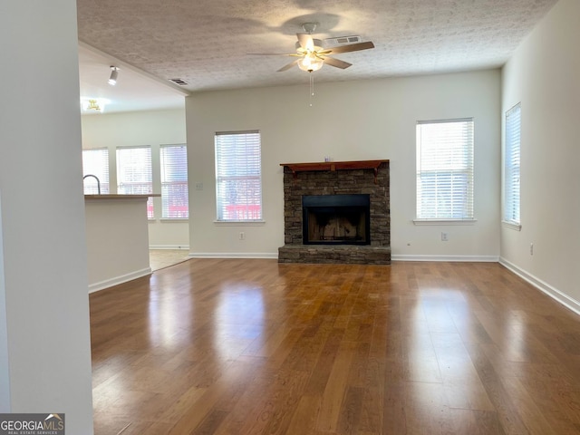 4299 High Country Dr, Douglasville, GA 30135 - unfurnished living room featuring hardwood / wood-style floors, a fireplace, a textured ceiling, and ceiling fan
