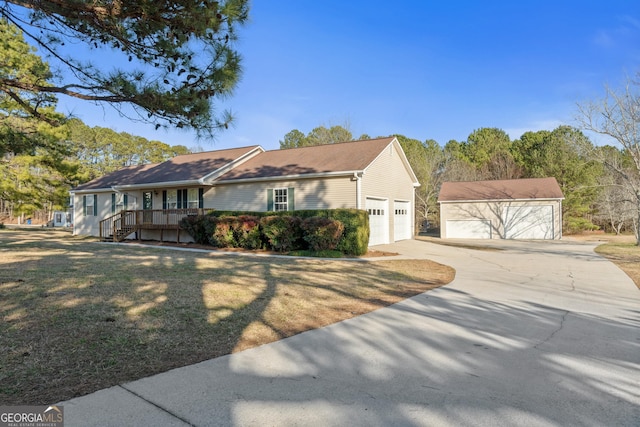 ranch-style house featuring an outbuilding, a garage, and a front lawn