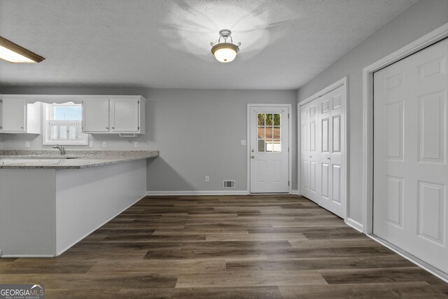 kitchen featuring white cabinetry, dark wood-type flooring, and a textured ceiling