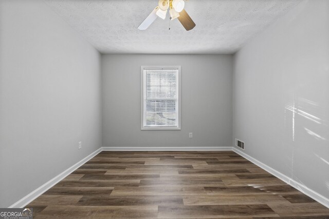 spare room with ceiling fan, dark wood-type flooring, and a textured ceiling