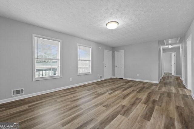 unfurnished room featuring hardwood / wood-style floors and a textured ceiling