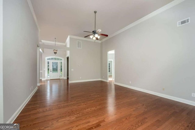 unfurnished living room with a high ceiling, crown molding, ceiling fan, and dark hardwood / wood-style flooring