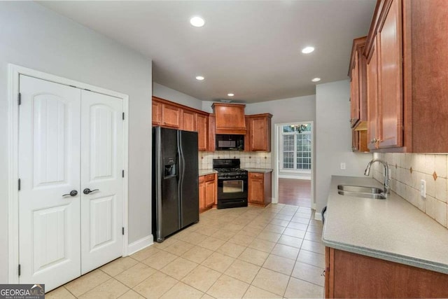 kitchen with light tile patterned flooring, sink, decorative backsplash, and black appliances