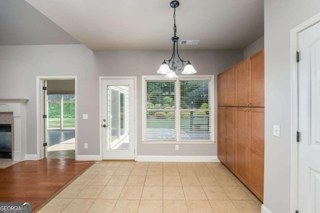 unfurnished dining area with a notable chandelier and light tile patterned flooring