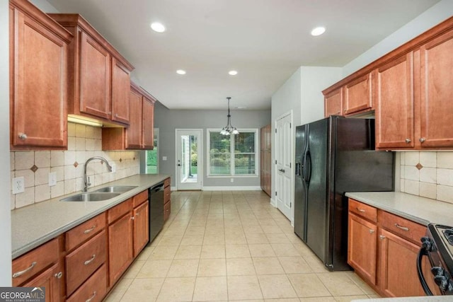 kitchen featuring sink, hanging light fixtures, light tile patterned floors, decorative backsplash, and black appliances