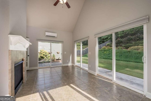 interior space featuring ceiling fan, an AC wall unit, a fireplace, and high vaulted ceiling