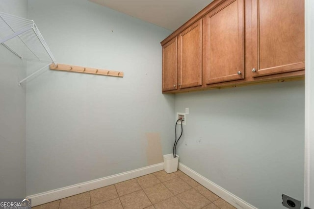 washroom with cabinets, hookup for a washing machine, hookup for an electric dryer, and light tile patterned floors