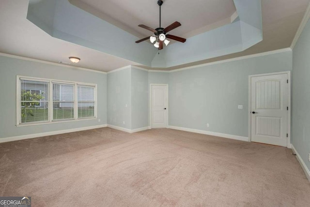 carpeted empty room featuring crown molding, a tray ceiling, and ceiling fan