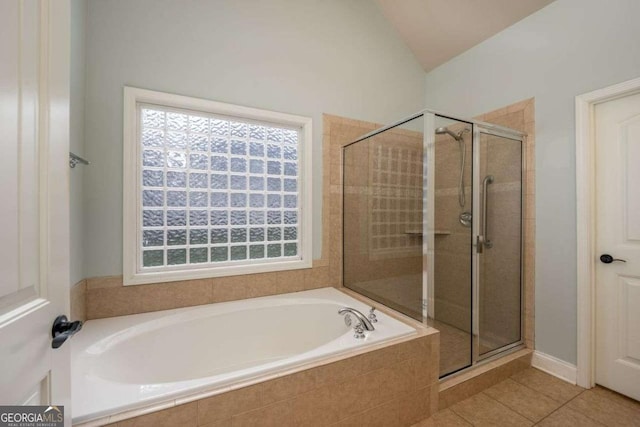 bathroom featuring lofted ceiling, shower with separate bathtub, and tile patterned flooring