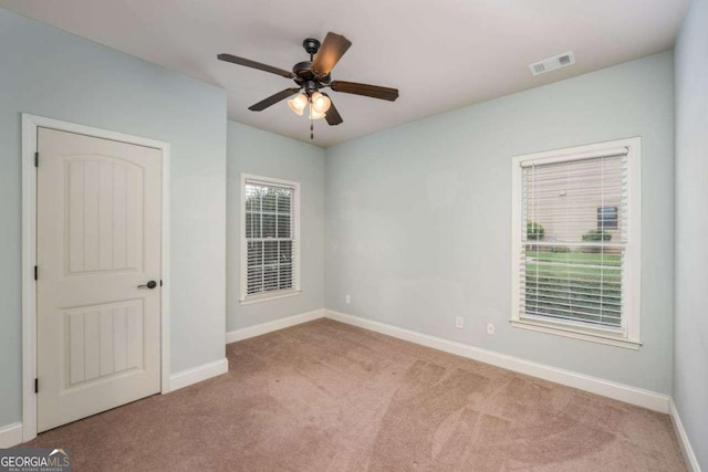 unfurnished room featuring light colored carpet and ceiling fan