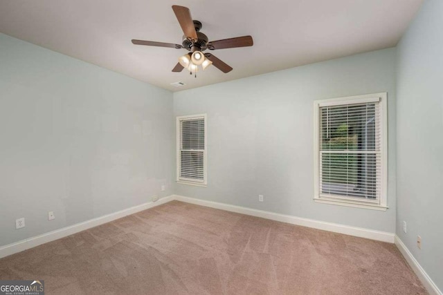 spare room with light colored carpet and ceiling fan