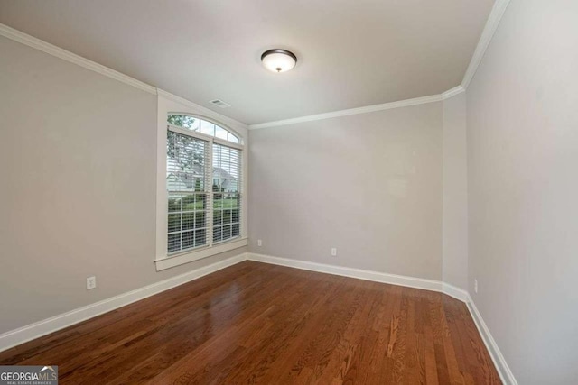 empty room featuring wood-type flooring and ornamental molding