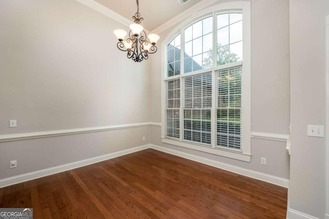 empty room with ornamental molding, a chandelier, and dark hardwood / wood-style flooring