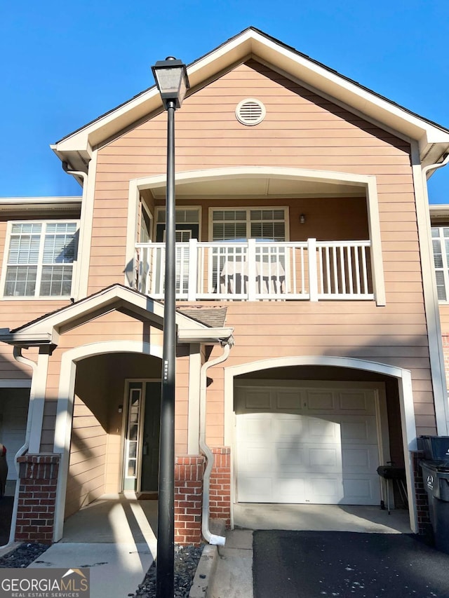 view of front of property featuring a garage and a balcony