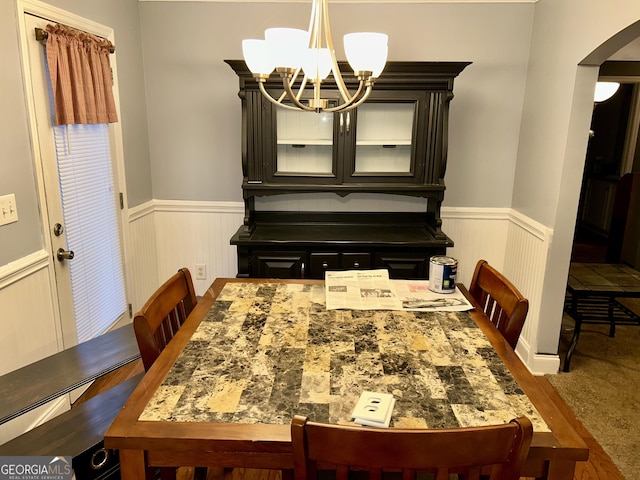 carpeted dining area featuring a notable chandelier