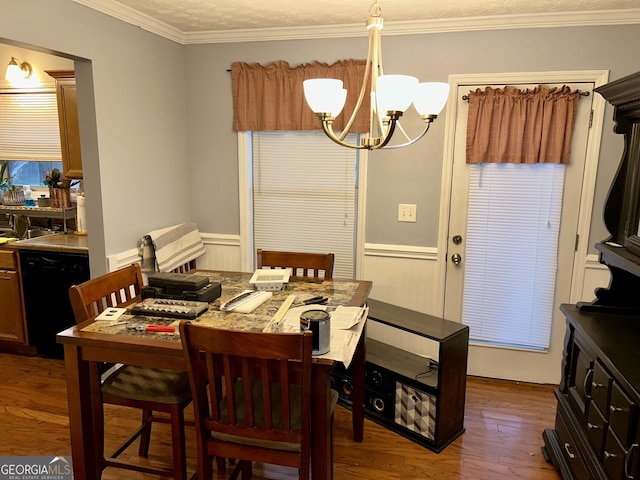 dining room featuring ornamental molding, hardwood / wood-style floors, a textured ceiling, and an inviting chandelier