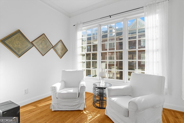 sitting room with wood-type flooring and ornamental molding